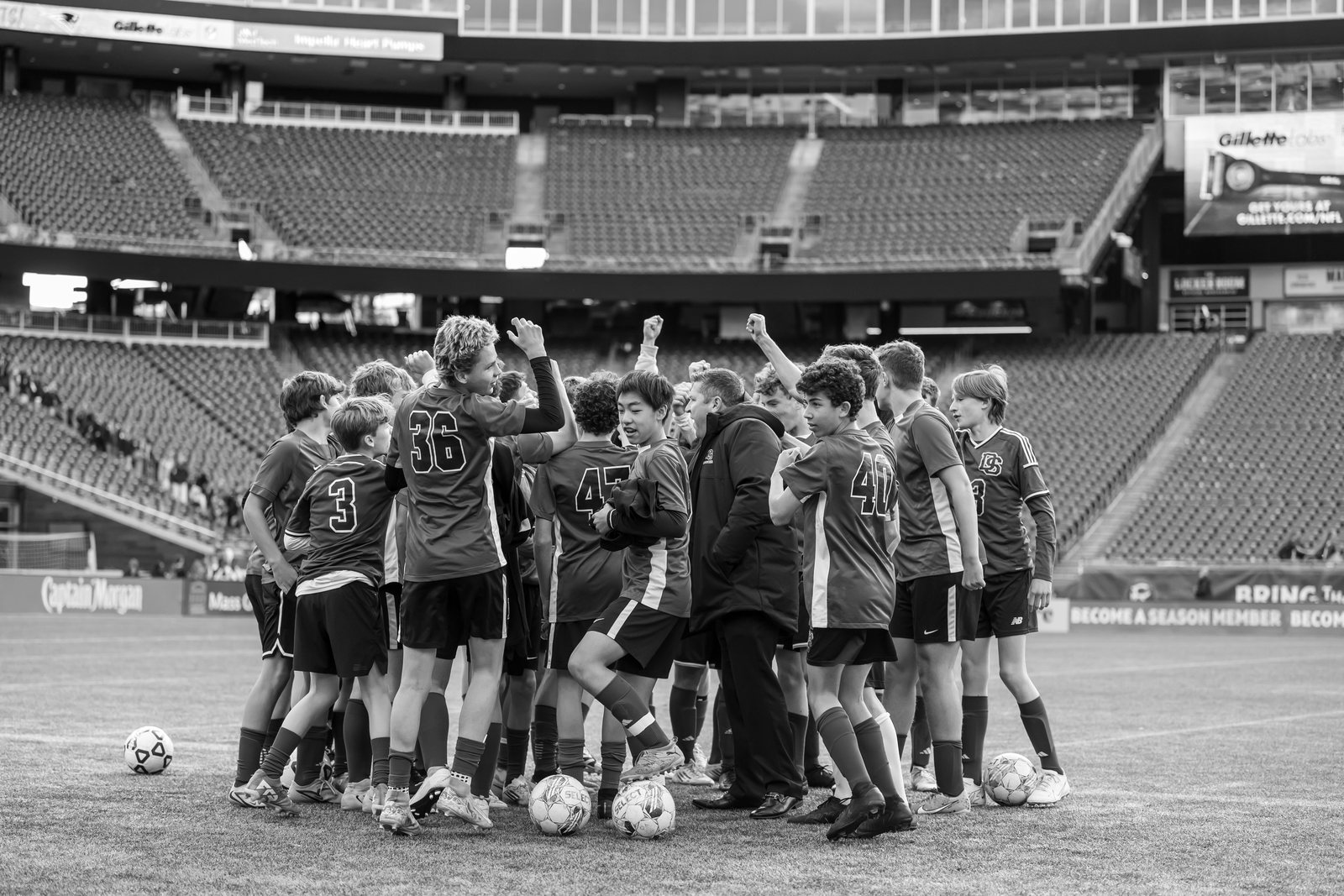 A team huddle in an empty stadium, black and white
